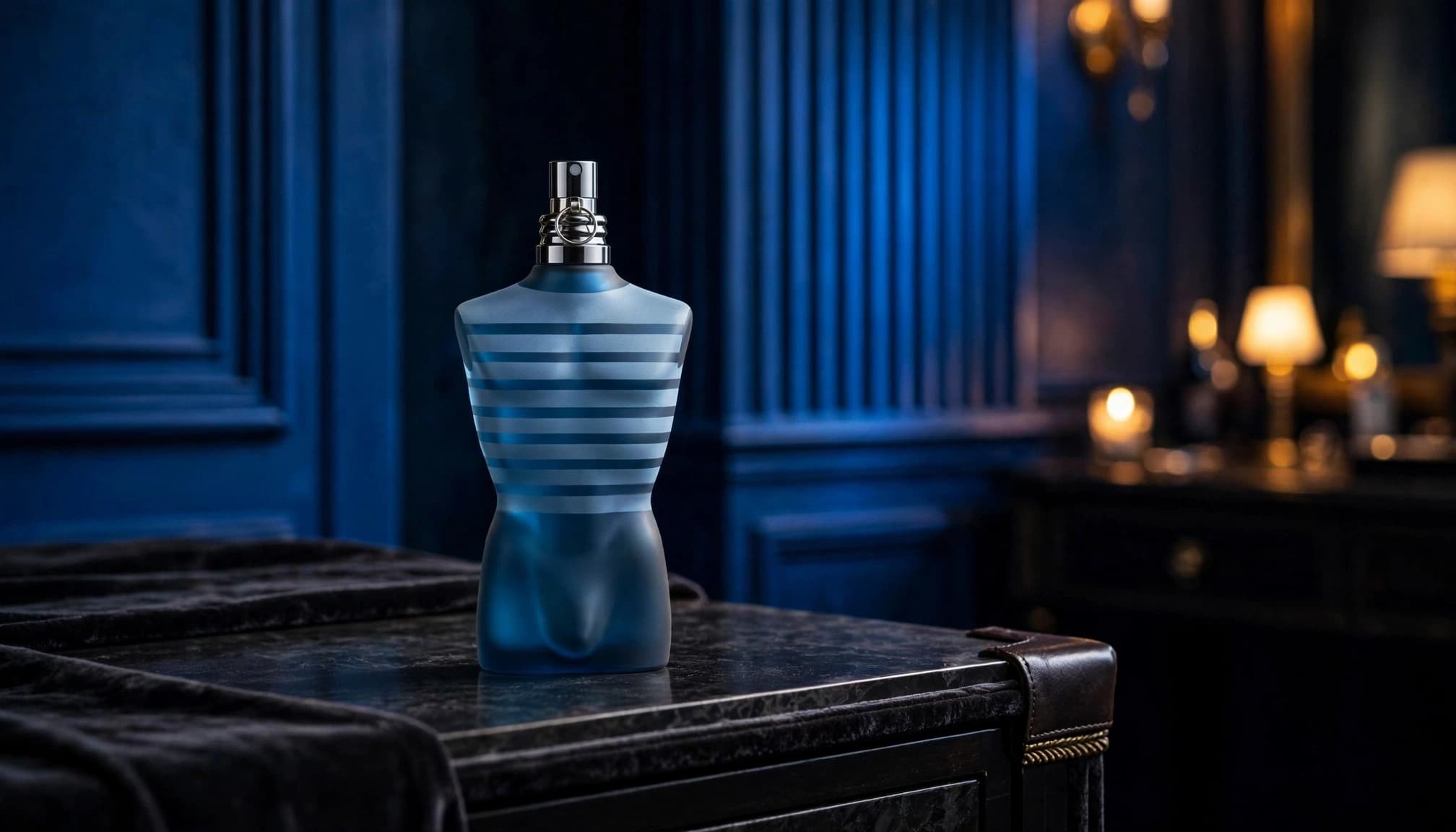 A blue torso-shaped fragrance bottle on a dark dressing table in a luxury room.